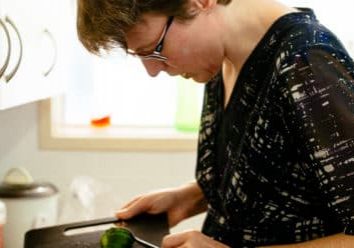 Supported Independent Living client prepares a salad for lunch